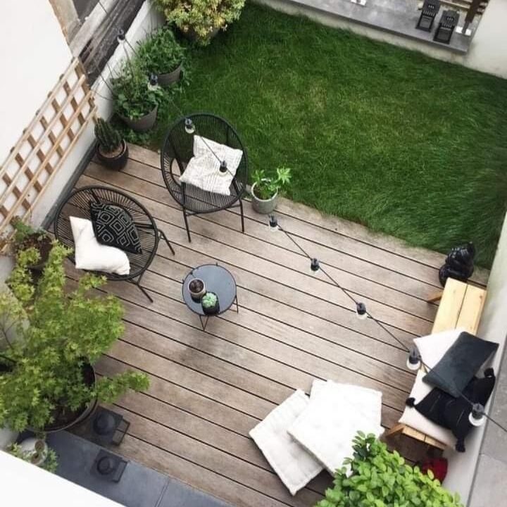 Patio pequeño con Decks en tono café. Sillas negras alrededor de una mesa. 